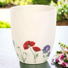 White ceramic plant pot with red and blue flower print on front