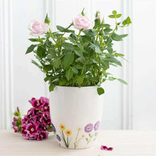 White ceramic plant pot with pink and purple wildflower artwork around base